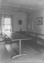 SA0673 - An unidentified photo showing a long trestle table, side chair, and long narrow bench against a wall.